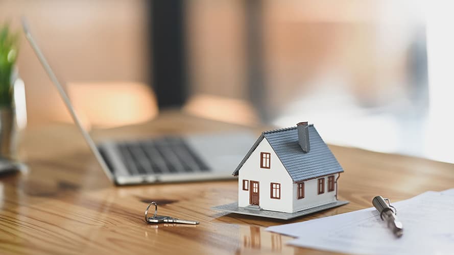 Desk with a model house and sales paperwork